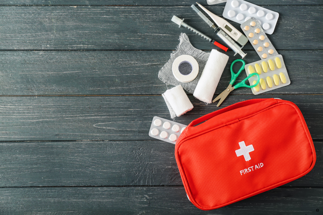 a first aid kit next to a syringe and other medical items. First aid skills